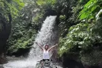 Woman enjoy ATV ride in ubud in waterfall track Bali